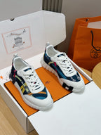 White leather-look sneakers with colorful geometric stripe panels and white laces