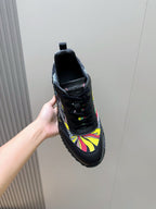 Black unisex sneaker side view with multicolor graphic panel and lace-up upper.