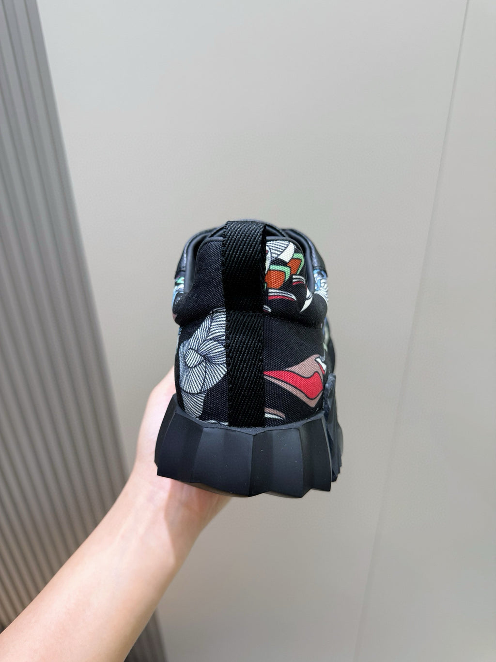 Black unisex sneaker heel with multicolor textile lining and lace-up strap.