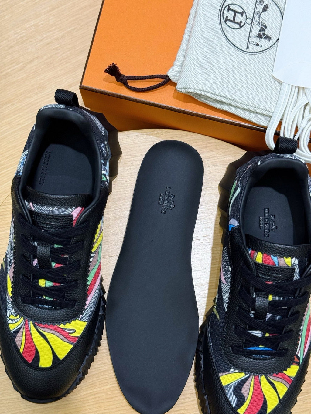Black unisex sneakers with multicolor graphic uppers and matching dark insole.