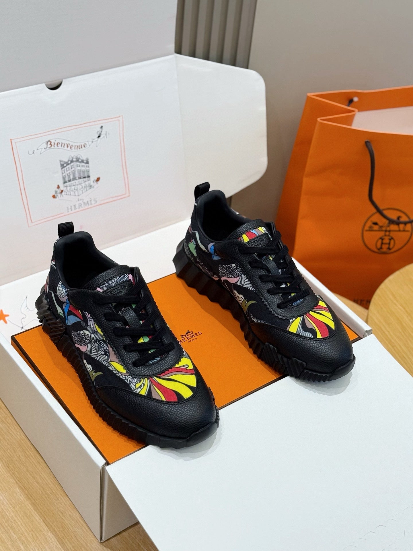 Black unisex lace-up sneakers with multicolor graphic uppers and chunky rubber sole.