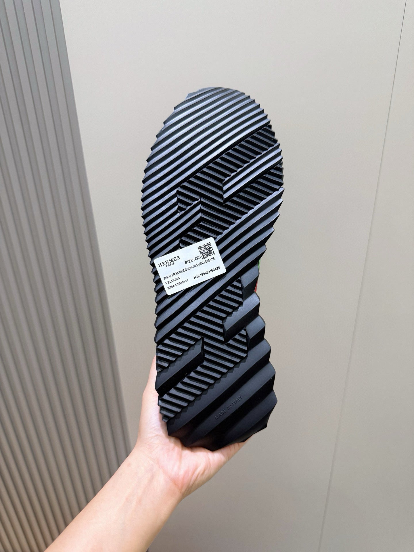 Black sneaker outsole with bold striped tread pattern.