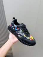 Black unisex lace-up sneaker with multicolor graphic side panels and chunky sole.
