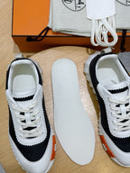 Hermes unisex sneakers close-up, black-and-white uppers with white laces on display.