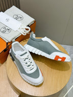 Hermes unisex lace-up sneakers, white/gray-green uppers with orange heel and sole accents