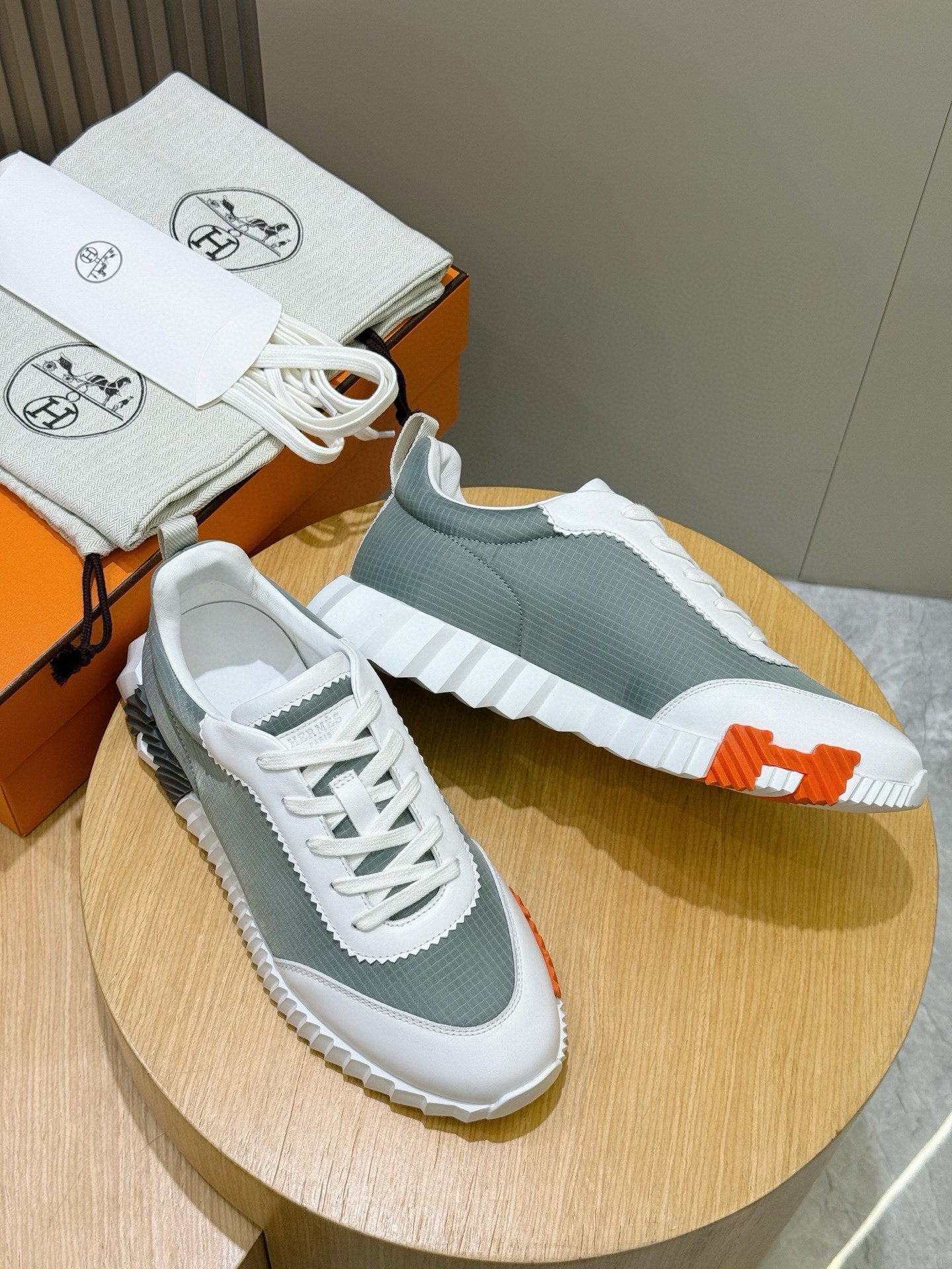 Hermes unisex lace-up sneakers, white/gray-green uppers with orange heel and sole accents