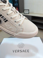Versace low-top sneakers close-up in off-white, lace-up with embossed pattern
