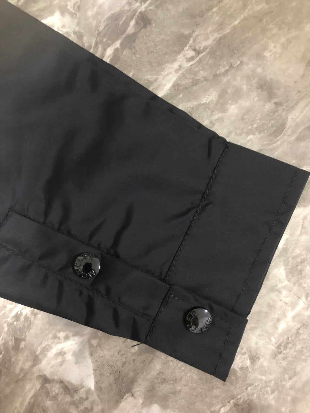 Moncler black long jacket hem with two snap buttons and stitched tab