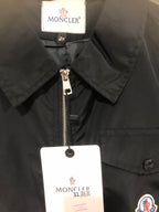 Moncler black long jacket with zip front, stand collar, and logo patch
