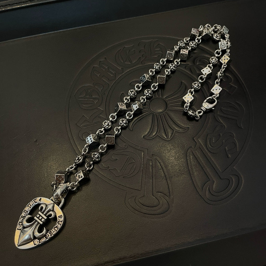 Silver-tone charm necklace with teardrop heart pendant and decorative link chain