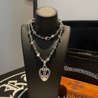 Silver-tone charm necklace with layered chain and heart pendant centerpiece
