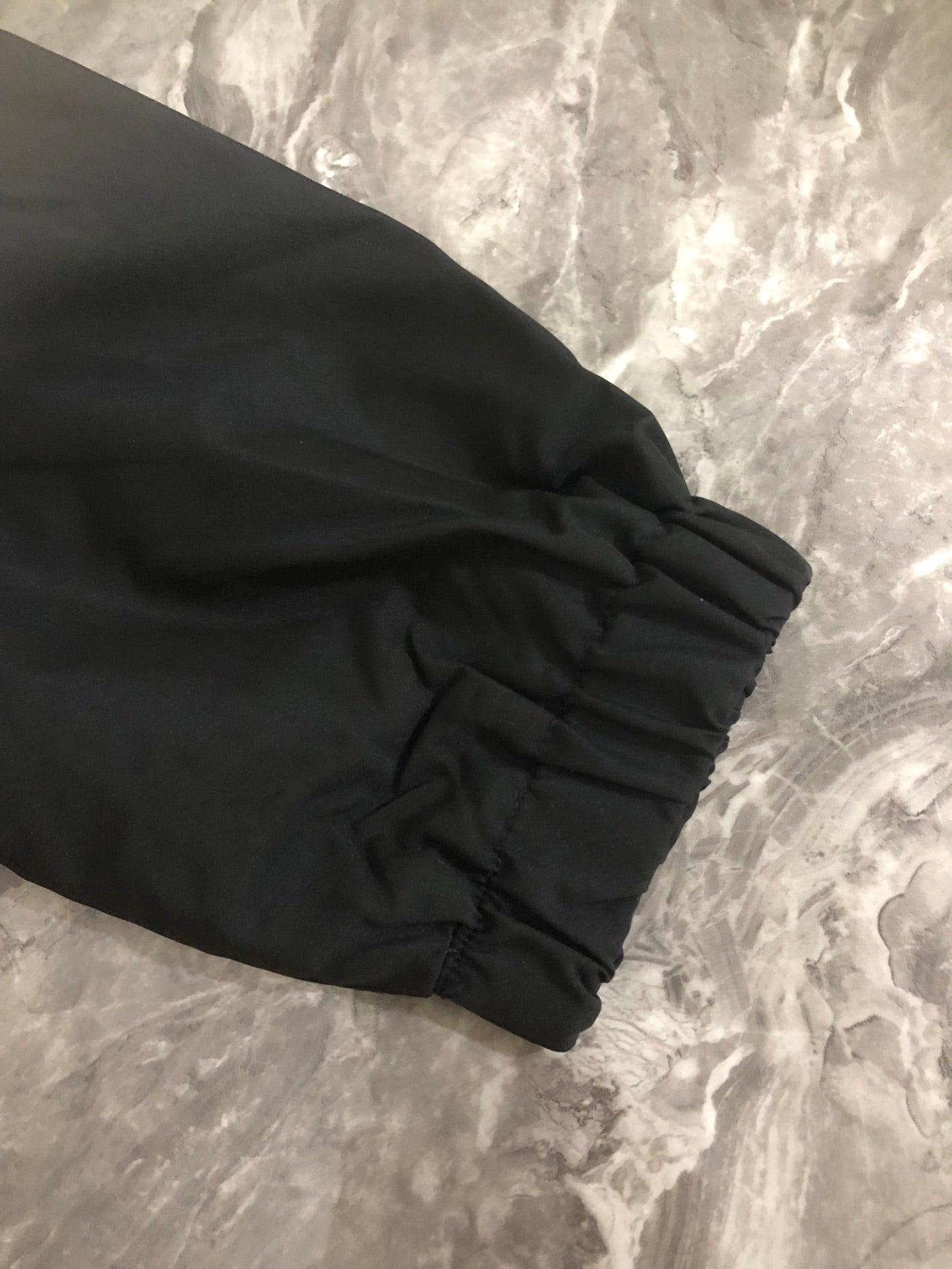 Black jacket sleeve cuff with gathered elastic hem