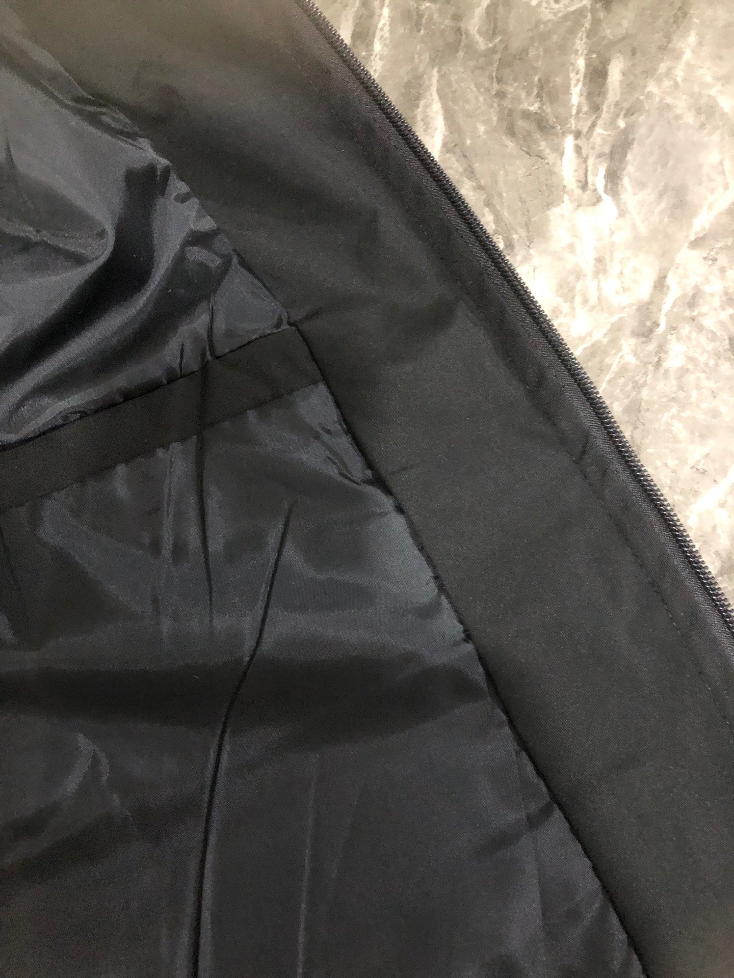 Black jacket zippered interior panel with stitched seam detail