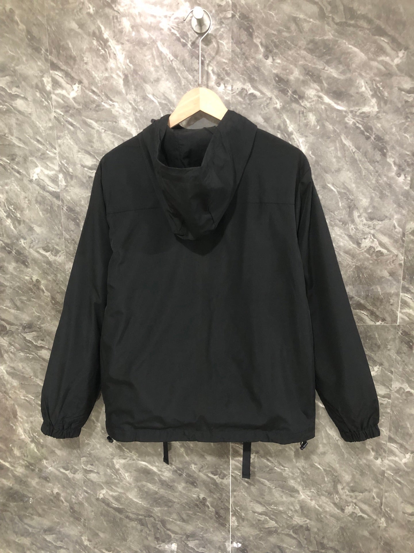 Black hooded long jacket with zip front and relaxed gathered hem