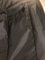 Windbreaker jacket inner pocket area, dark fabric with seams