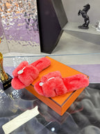 Red plush slide sandals with thick double straps and white circular logo tags