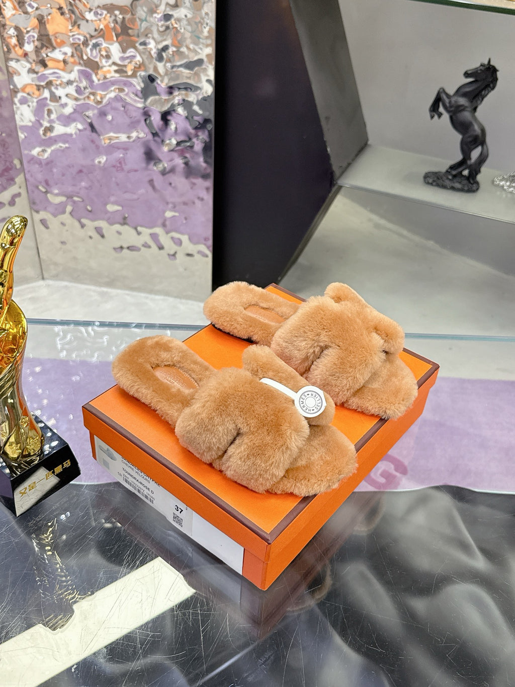 Women's tan shearling slide sandals with thick crossover straps and round logo badge