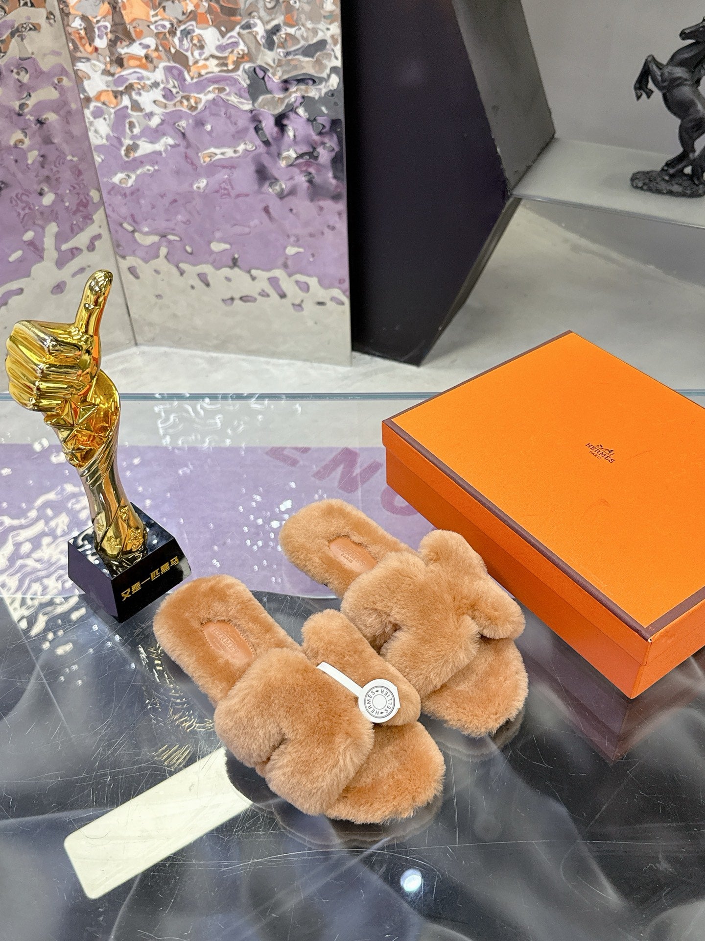 Women's tan plush shearling slide sandals with crossover straps and round logo badge detail