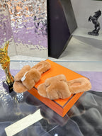 Women's tan plush shearling slide sandals with padded crossover band and round logo badge