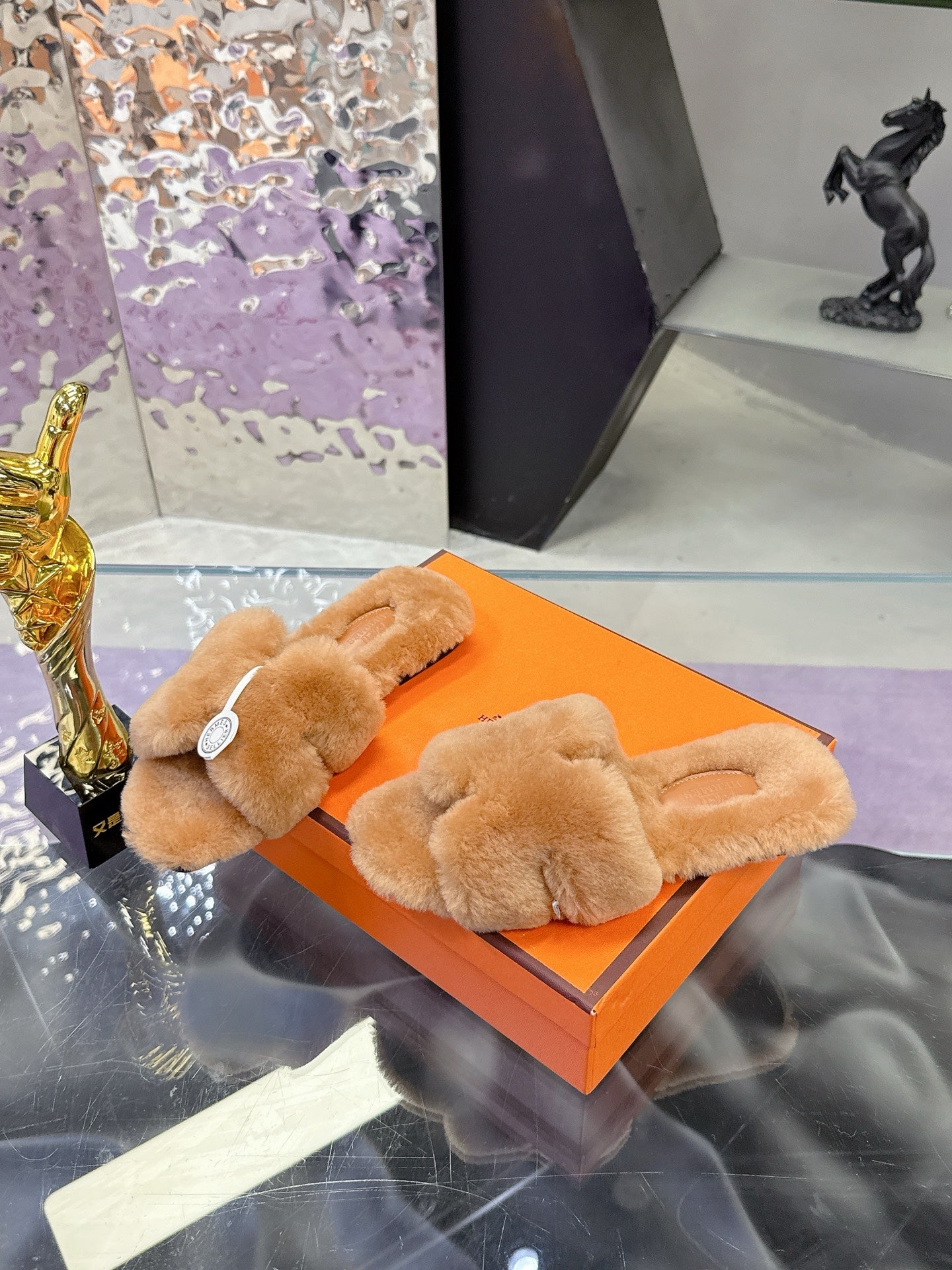 Women's tan plush shearling slide sandals with padded crossover band and round logo badge
