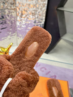 Brown plush slide sandals, close-up of textured footbed and inner logo