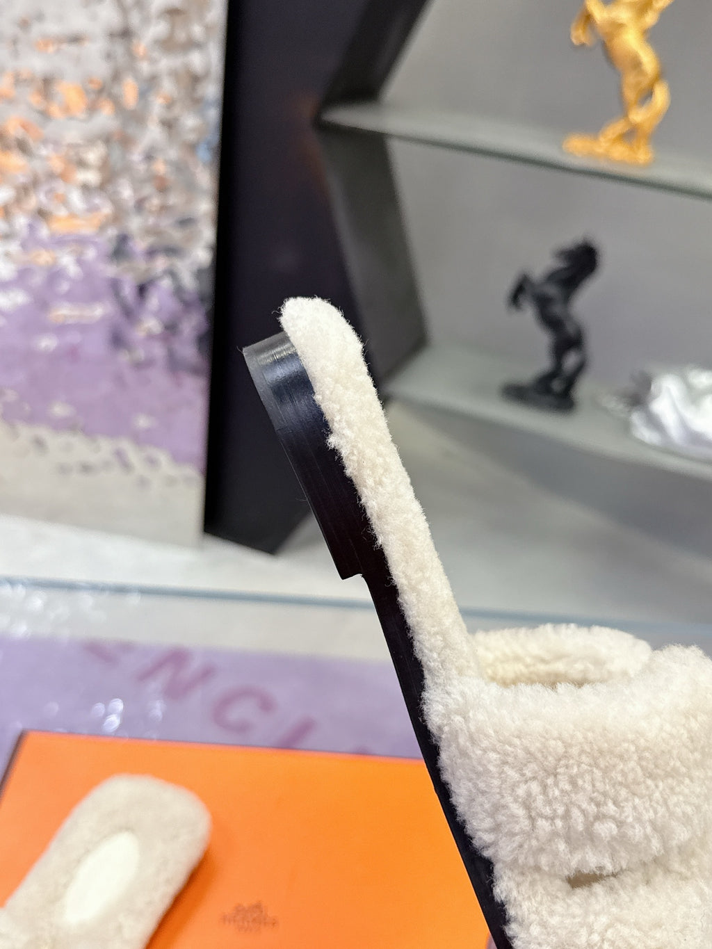 Hermes ladies shearling slide side view, cream fuzzy strap with logo patch