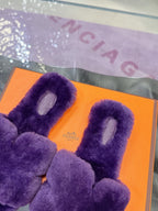 Hermes ladies purple faux-fur slides with bow strap, close-up on orange box