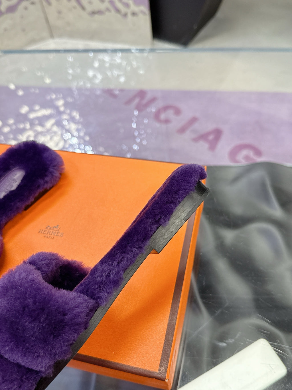 Hermes ladies purple faux-fur slides with bow strap, side close-up on orange box