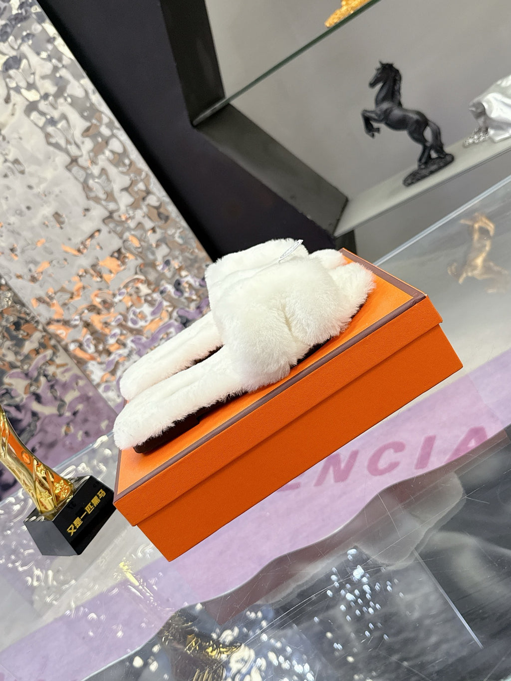 White plush slide sandal with thick cushioned top and round logo patch