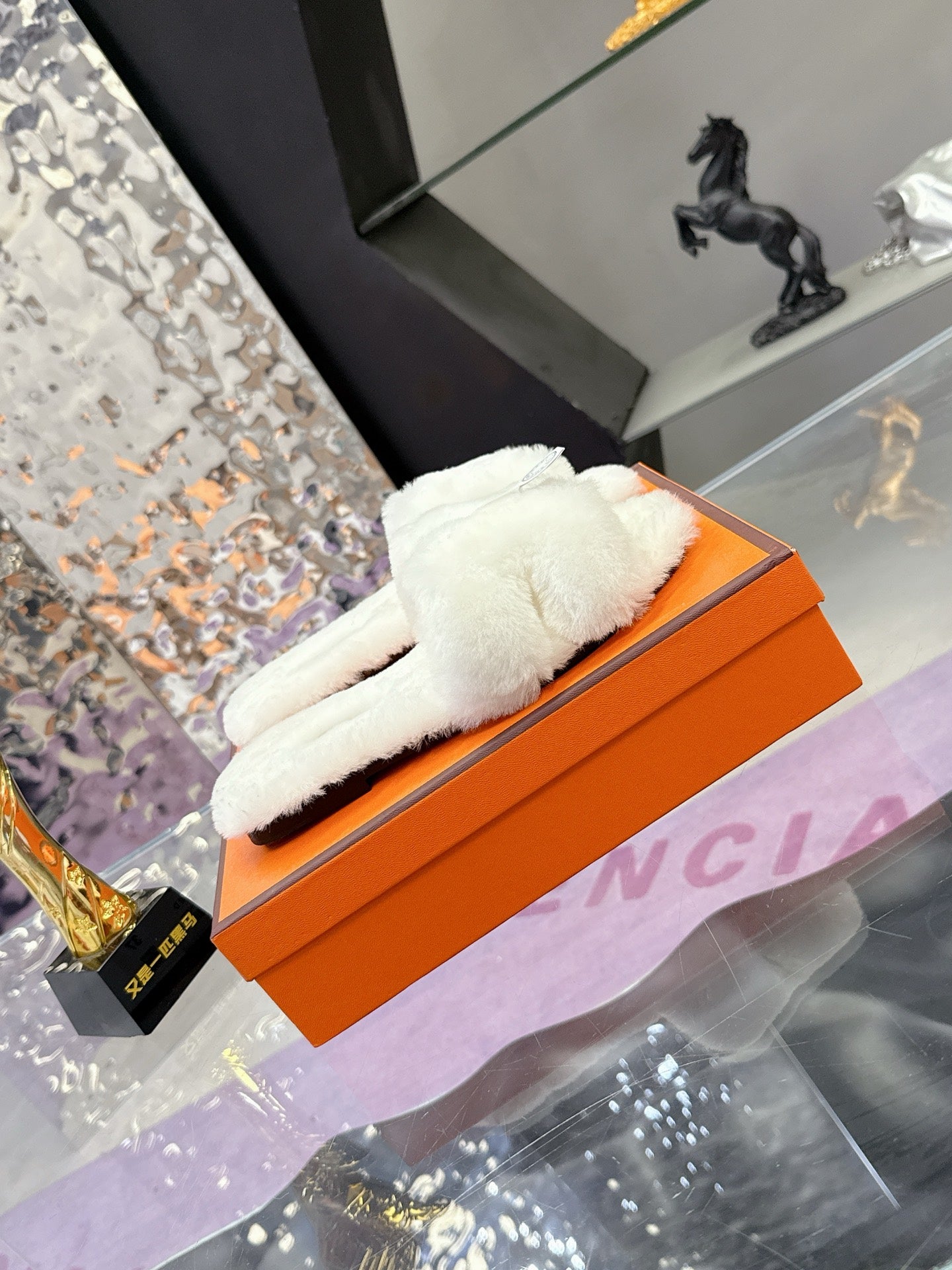 White plush slide sandal with thick cushioned top and round logo patch