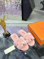 Pink faux-fur slide sandals with triple wide crossed straps and round logo medallion
