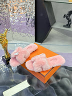 Pink faux-fur slide sandals with crossed straps and round logo medallion