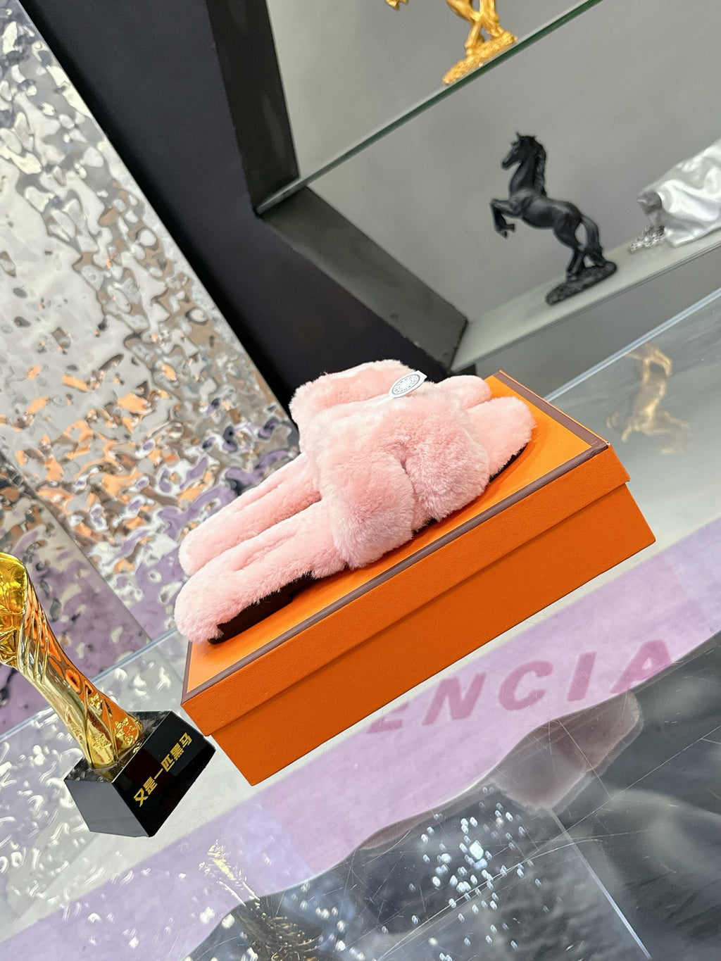 Pink faux-fur slide sandals with thick crossed strap and small logo tag