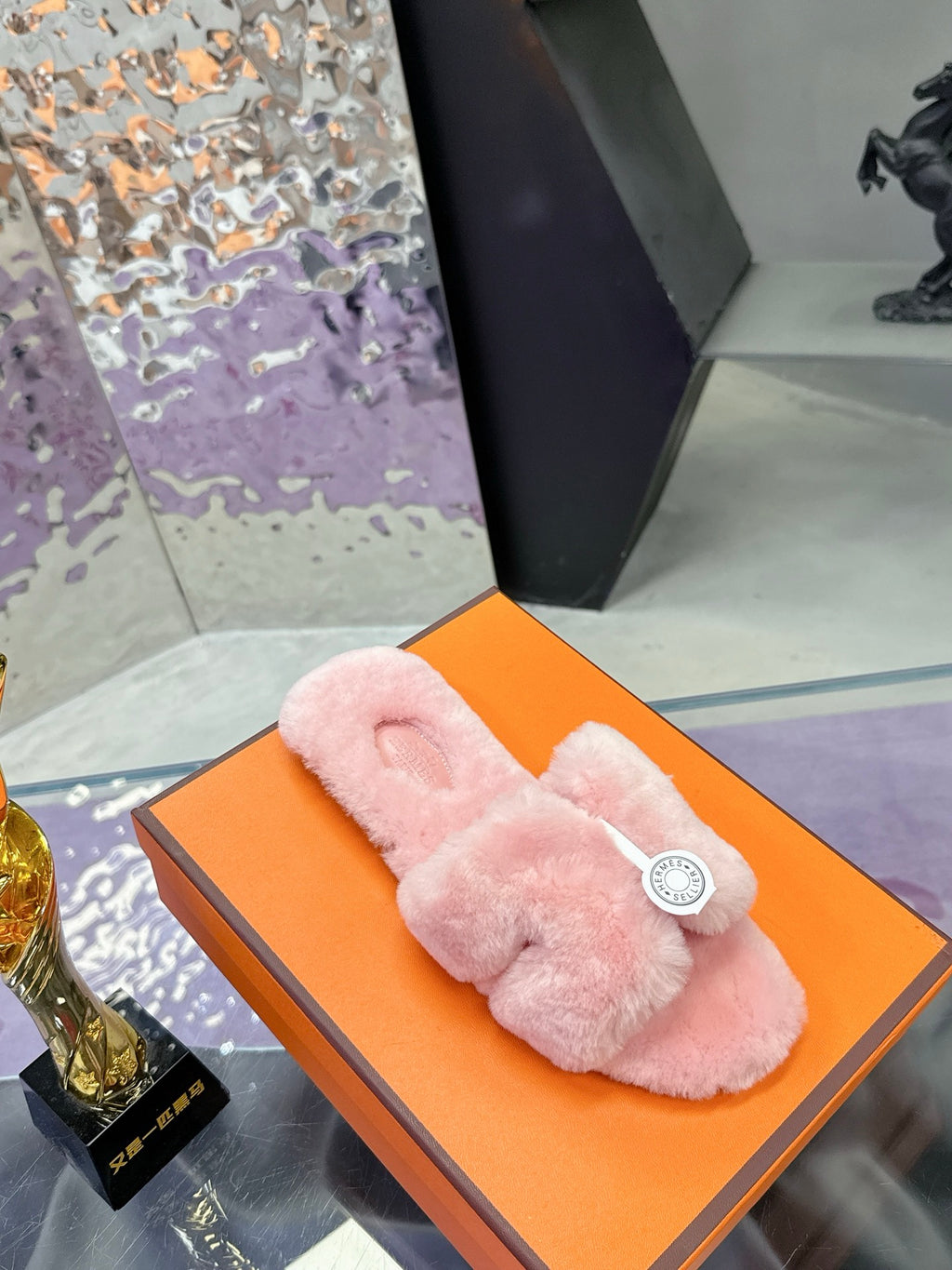Pink faux-fur slide sandals with single top cross strap and round logo medallion