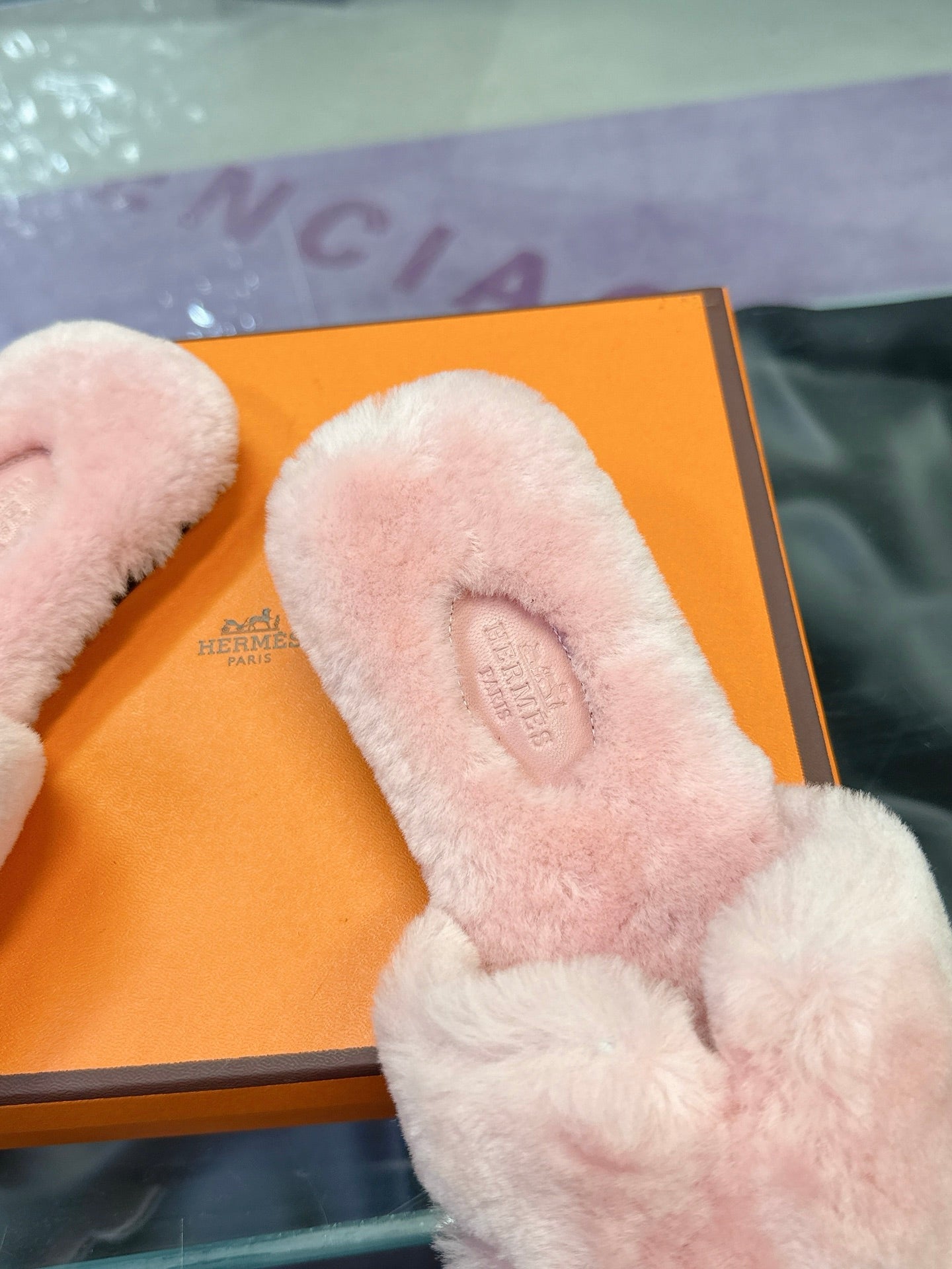 Light pink Hermes faux-fur slide sandals with padded toe area and embossed logo