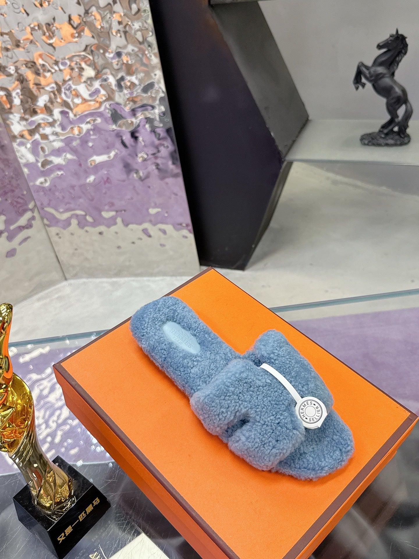 Hermes light blue plush slide sandals on an orange box, white strap and round emblem
