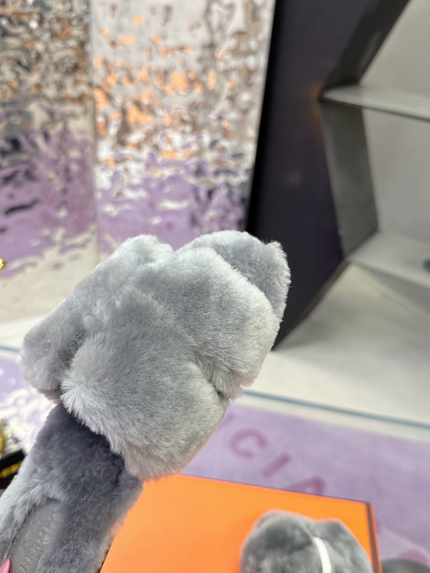 Hermes luxury shoes, close-up of grey plush strap on orange box