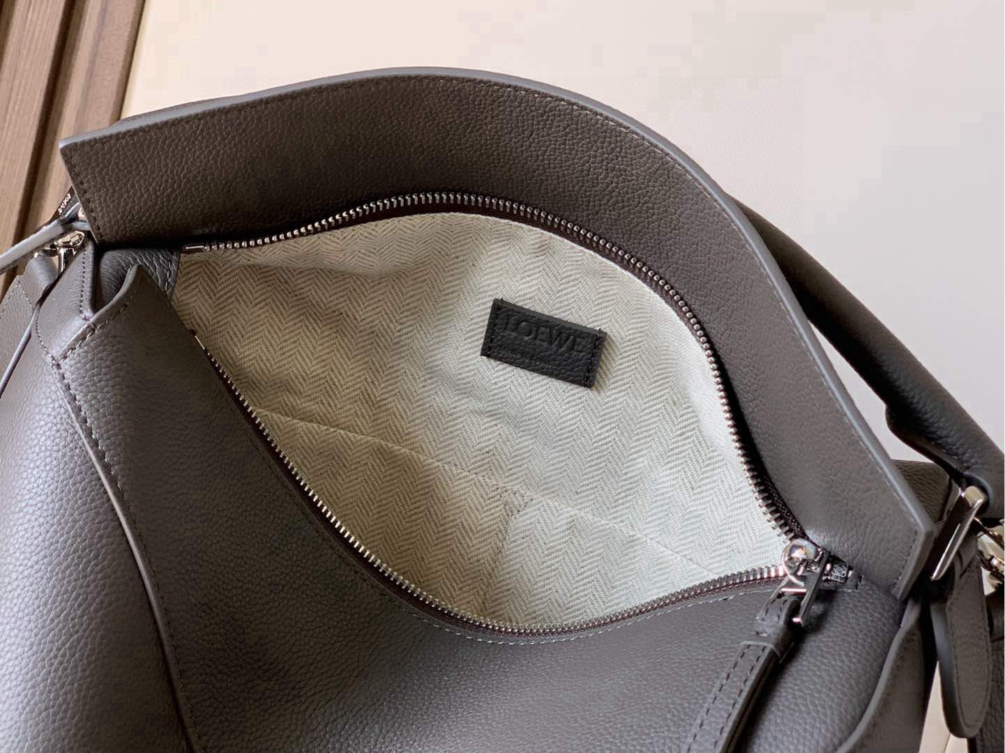 Loewe gray leather bag interior with zip-top lining and Loewe logo patch
