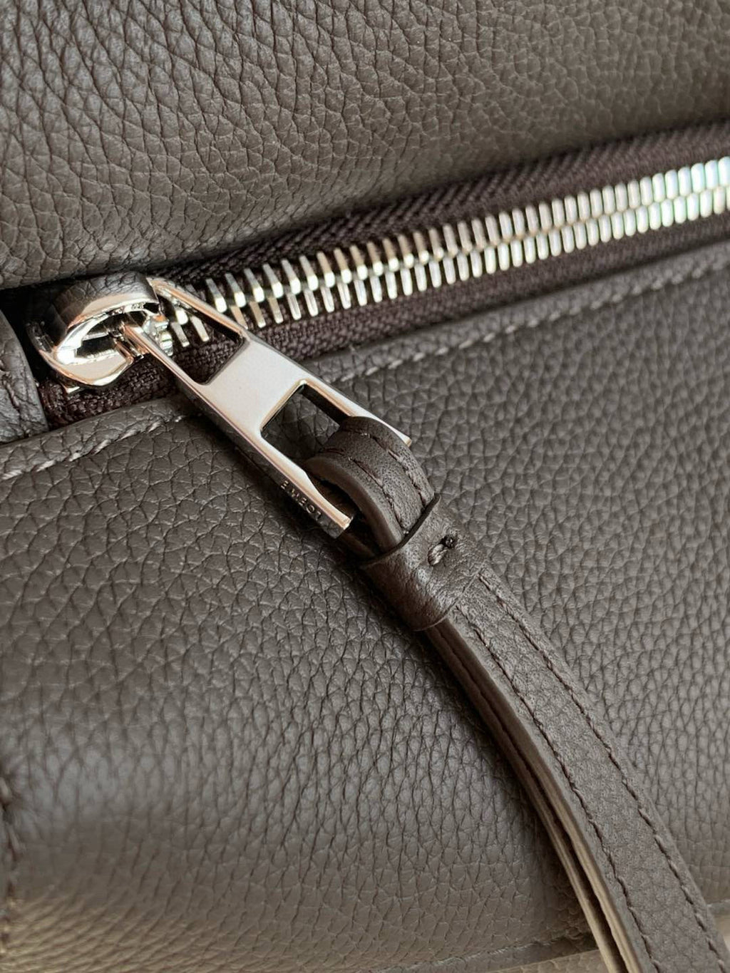 Loewe men's bag zipper pull and stitching detail on dark gray leather
