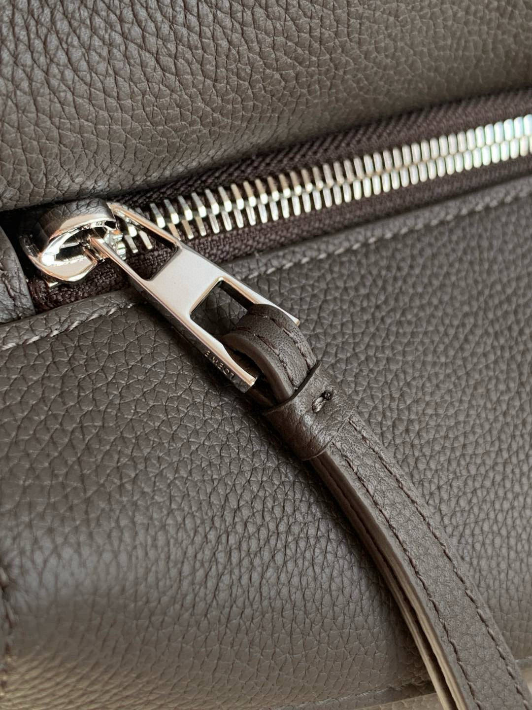 Loewe men's bag zipper pull and stitching detail on dark gray leather