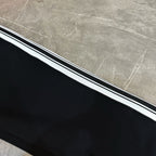 Black track pants with triple white-and-black side stripe detail