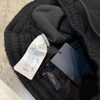Black jogger pants with elastic waistband, inner fabric, and attached product tags