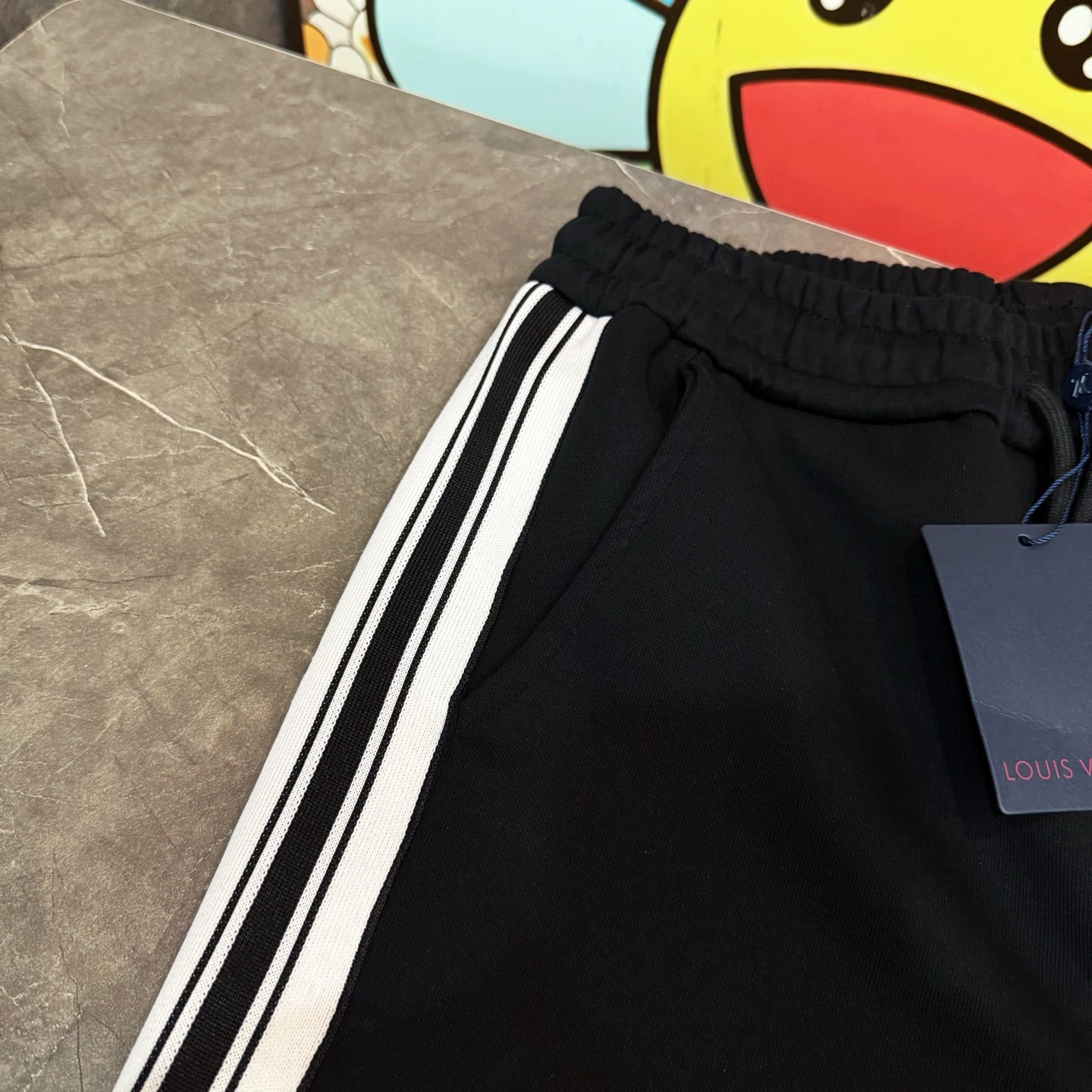 Black jogger pants with elastic waistband and white side stripes