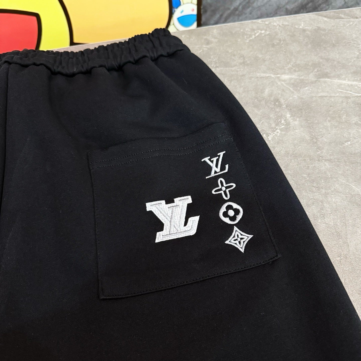 Louis Vuitton black pants pocket with LV logo patch and emblem symbols