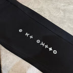 Louis Vuitton black pants detail with small LV and quatrefoil logos