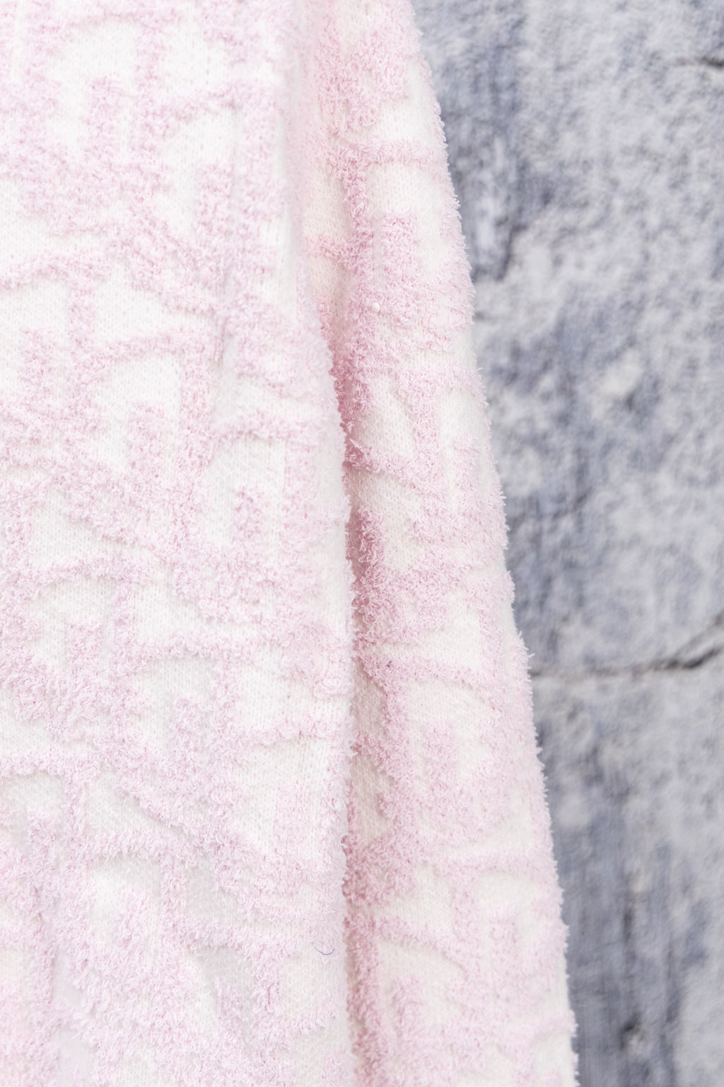 Pale pink textured knit cardigan fabric close-up