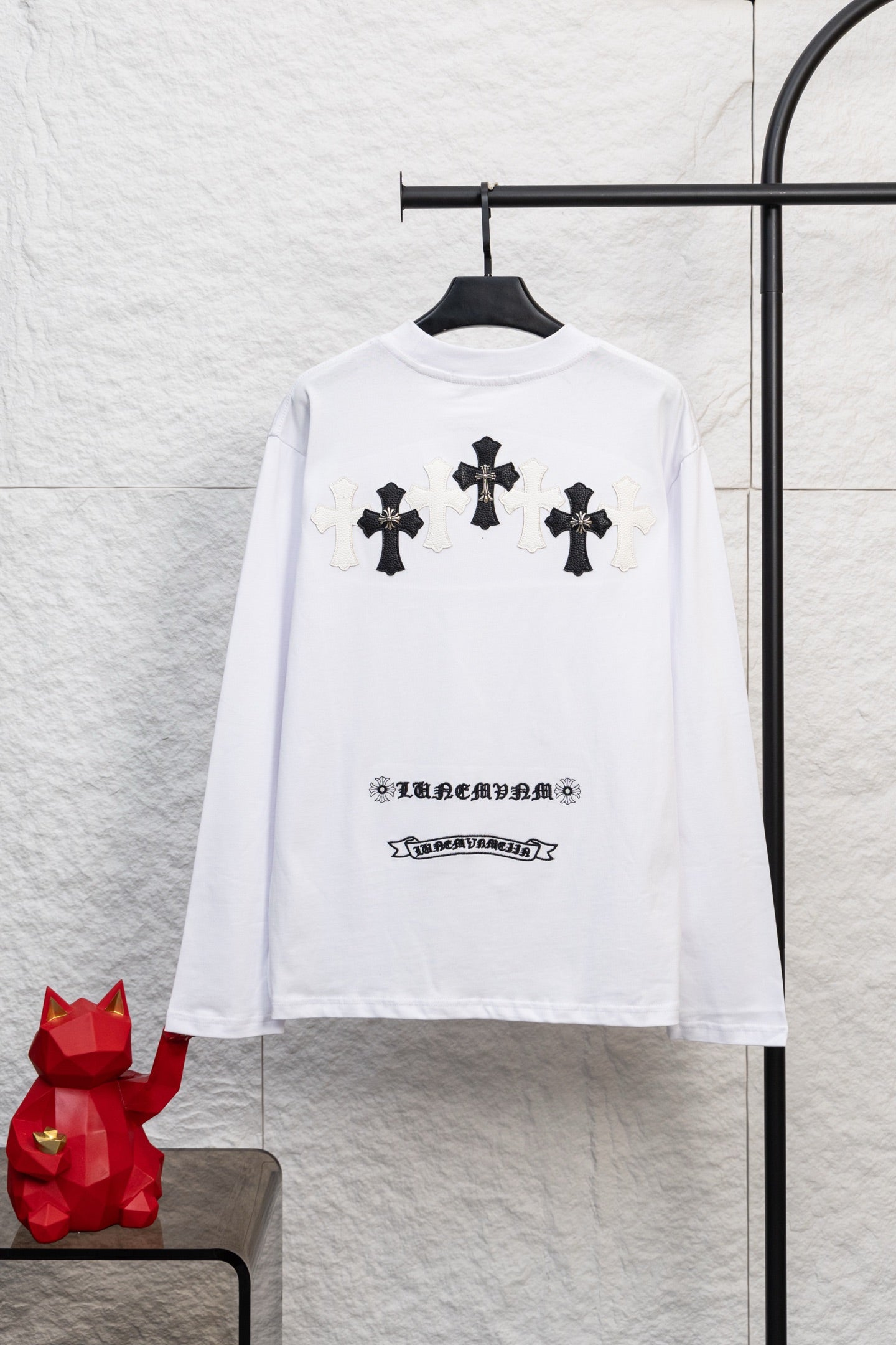 White long-sleeve T-shirt with multiple black cross prints and small chest text