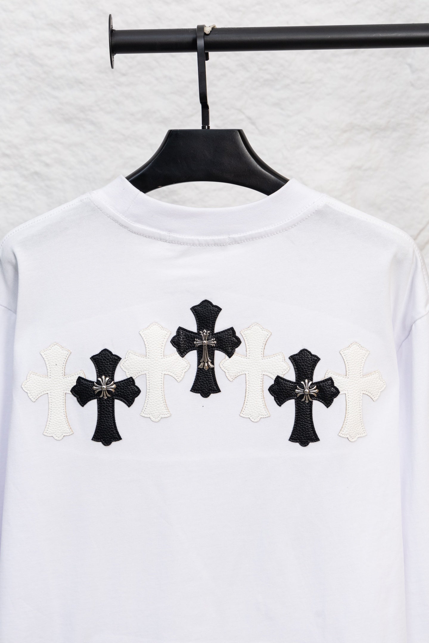 White long-sleeve T-shirt with large black cross appliques across the chest