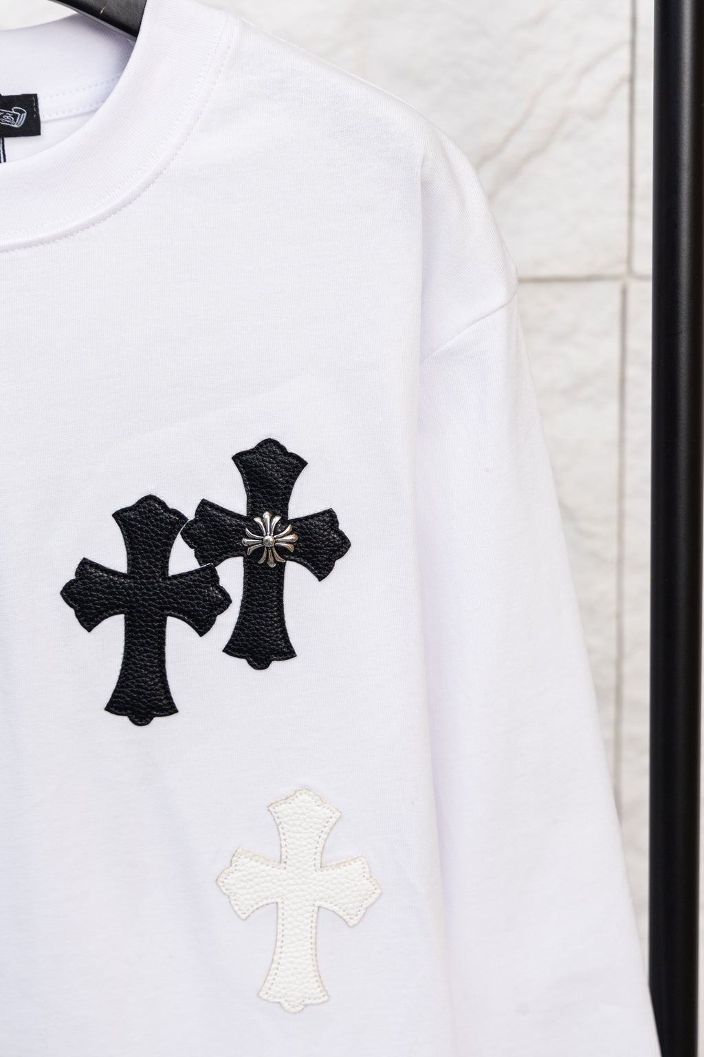 White long-sleeve T-shirt with black cross applique and small light cross below