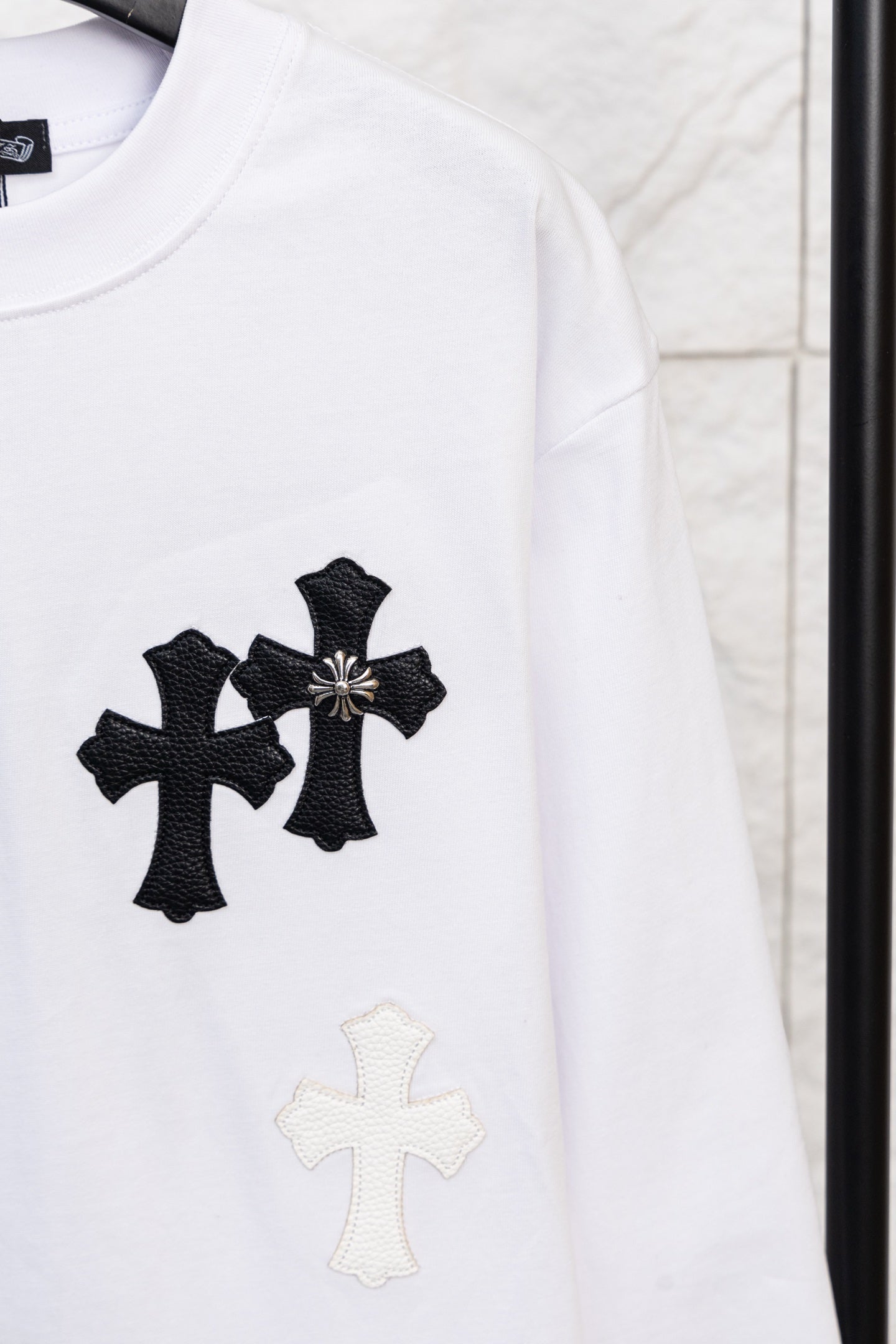 White long-sleeve T-shirt with black cross applique and small light cross below